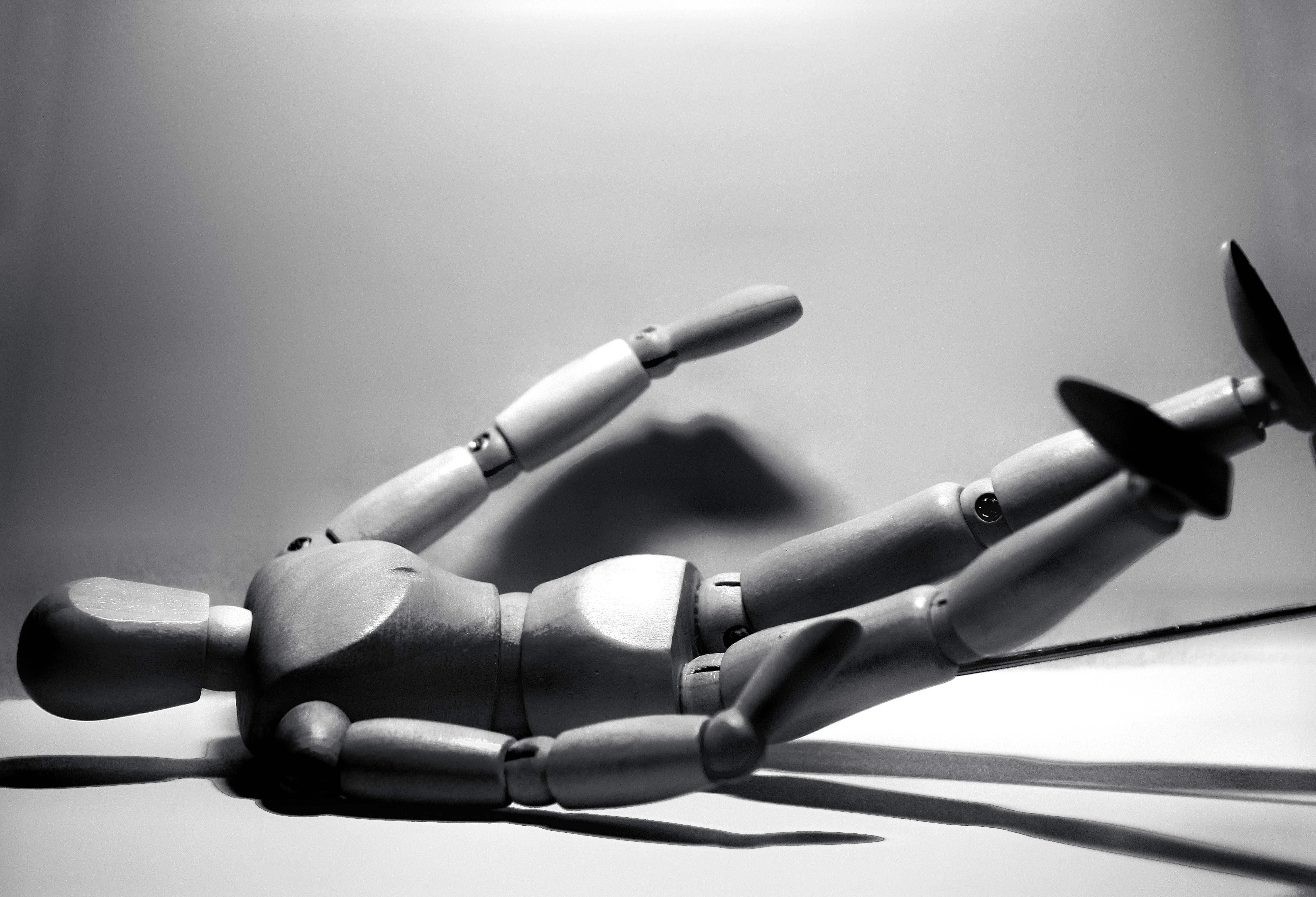 Black-and-white photo of a wooden artist mannequin lying on its side